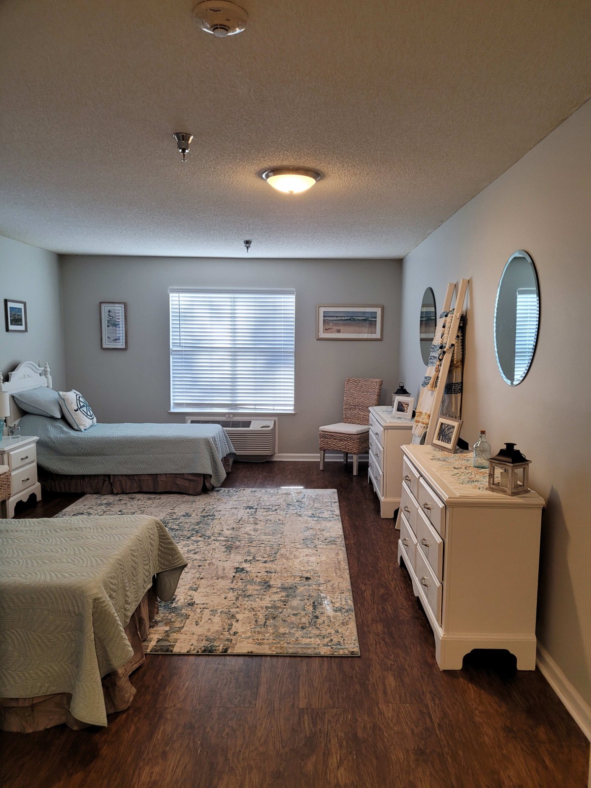 A cozy bedroom with twin beds, adorned with elegant furniture and decor elements.