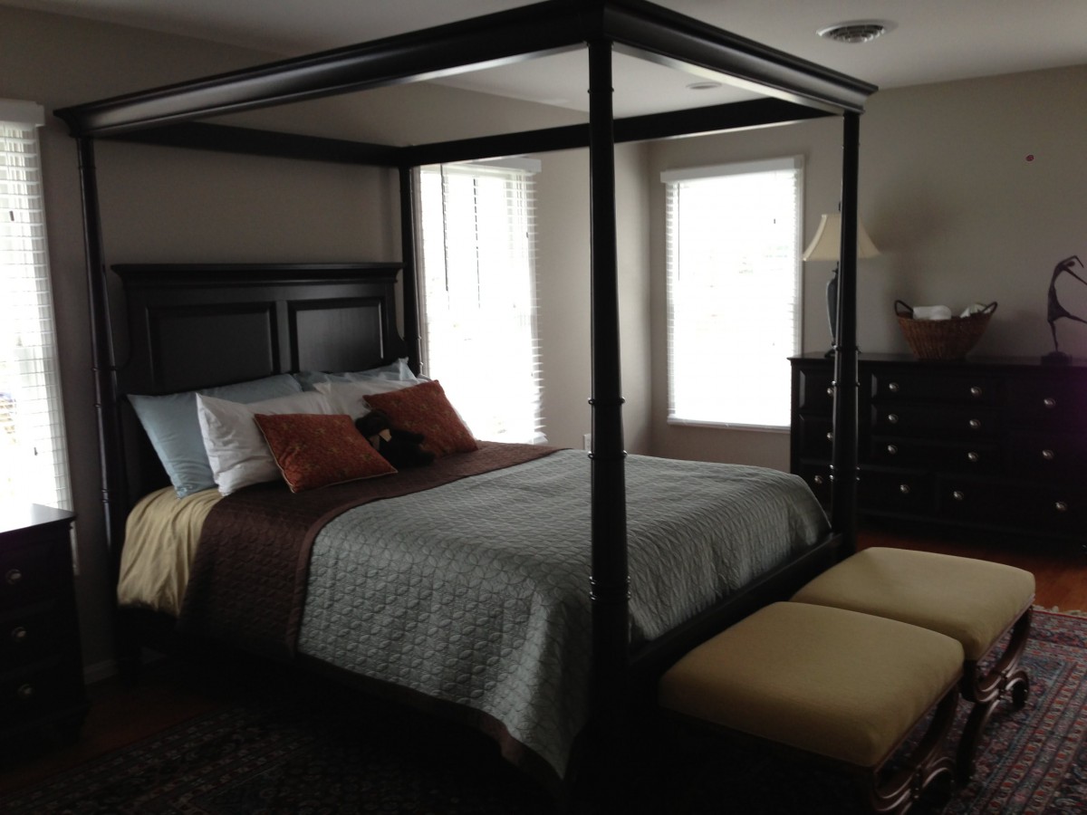 A stylish bedroom featuring a canopy bed and modern decor.