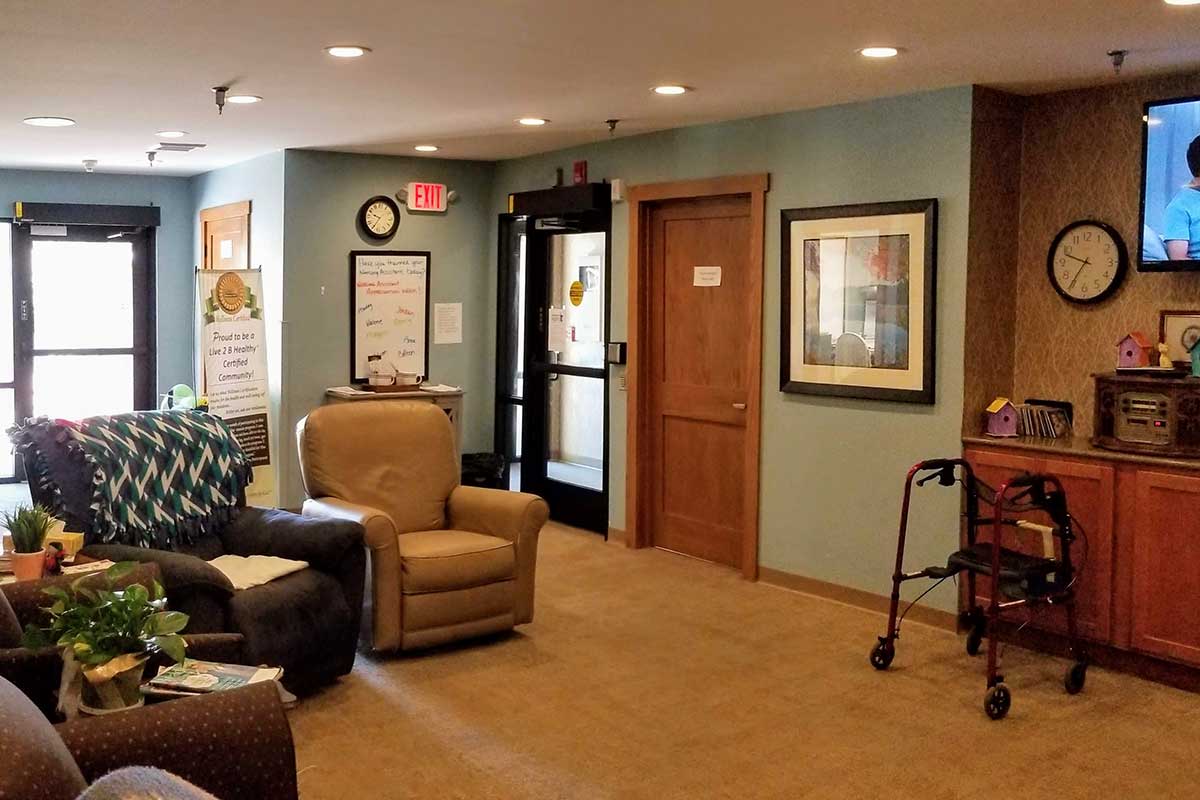 A cozy reception area with armchairs and framed artwork on the walls.