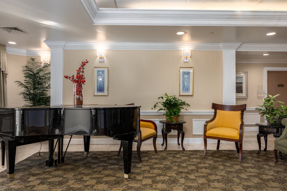A sophisticated lounge area featuring a grand piano, elegant seating, and tasteful decor.