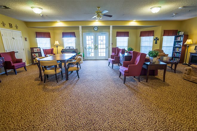 A cozy living room with comfortable seating, tables, and natural lighting.