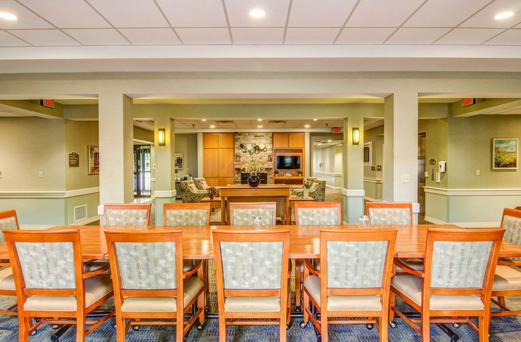 A modern dining room interior with wooden furniture and ambient lighting.