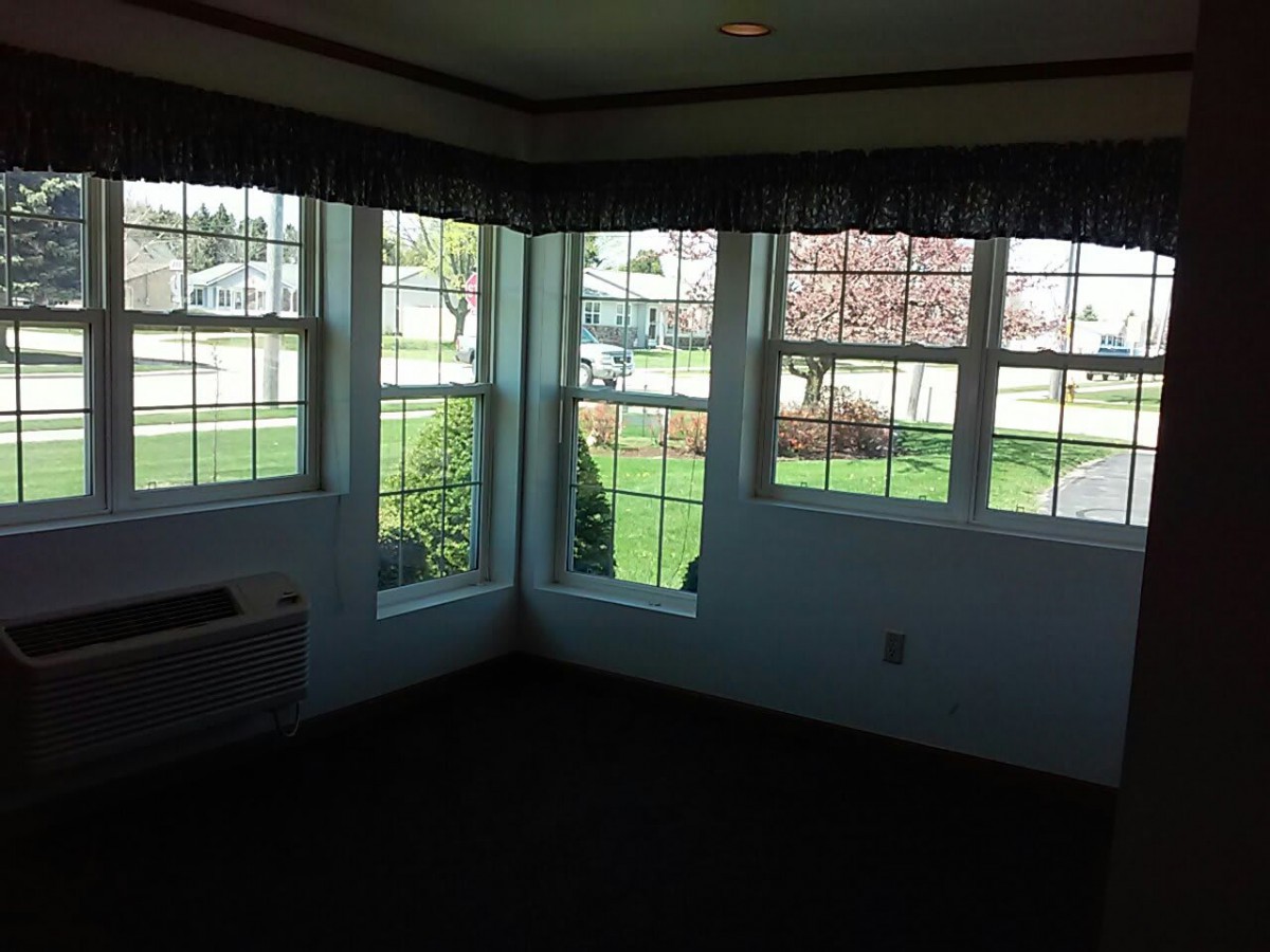 An empty room with large windows providing a view of the outdoors.