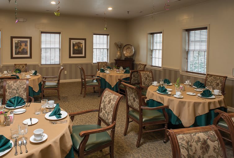 A cozy dining room with tables and chairs set for a meal.