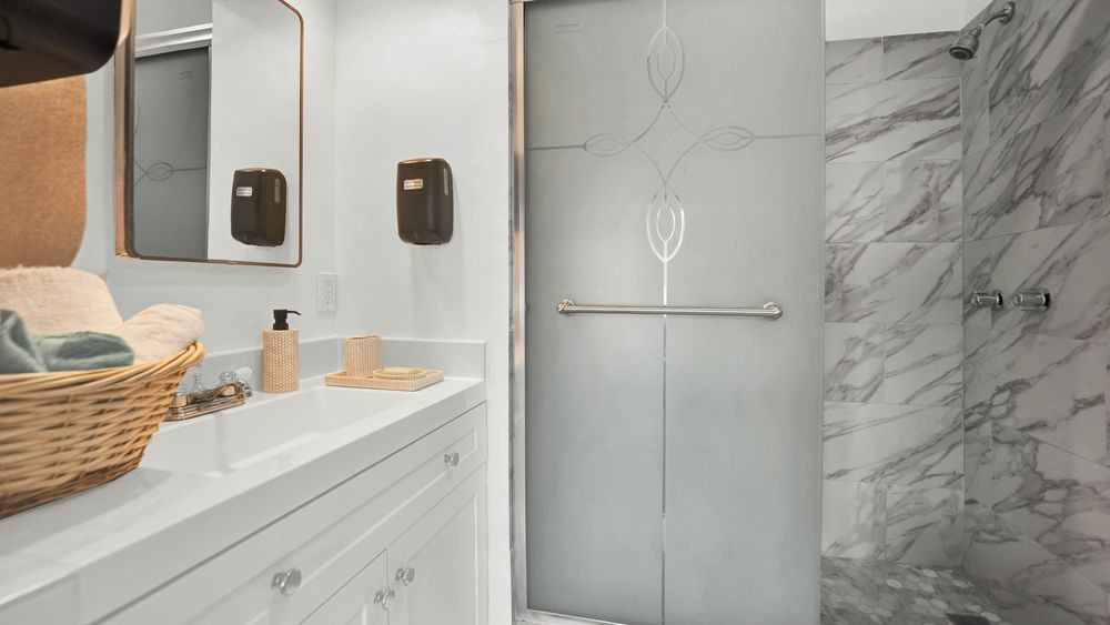 A modern bathroom with a frosted glass shower door and sleek fixtures.
