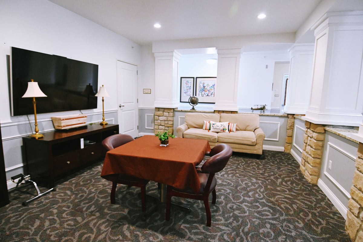 A cozy living room with a sofa, table, and wall-mounted television.
