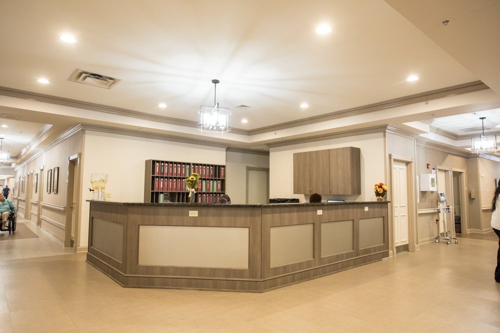 A modern reception desk in an office setting with ample lighting and organized shelving.