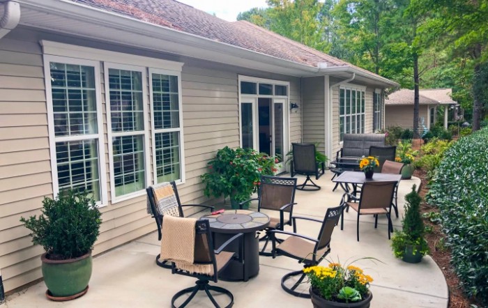 A cozy patio setup with chairs and tables beside a house.