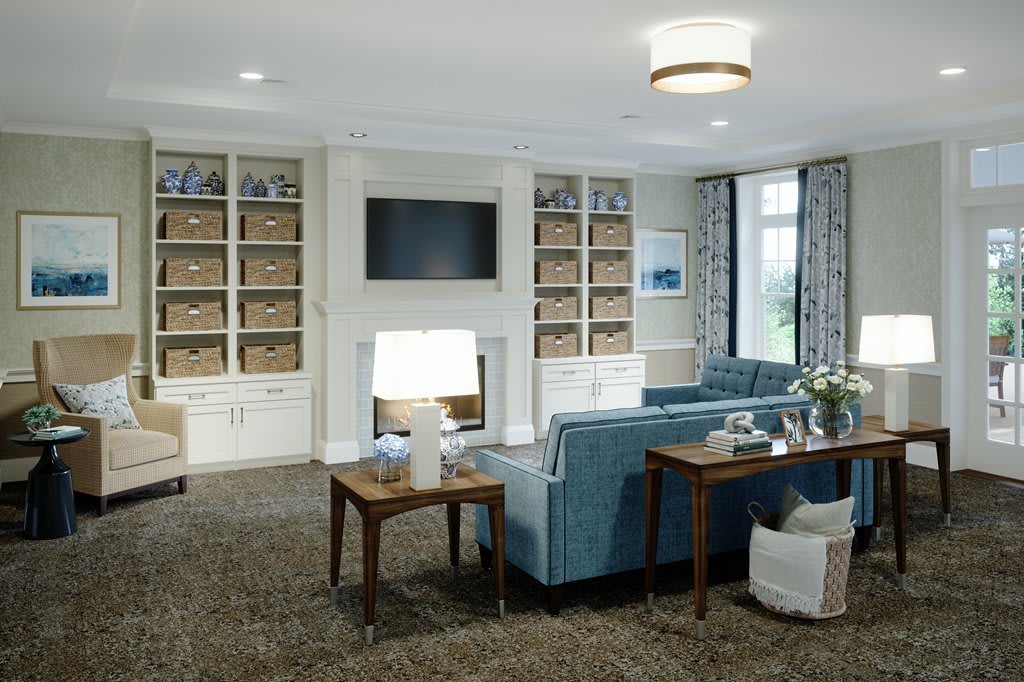 A stylish living room featuring a blue sofa, built-in bookshelves, and a mounted television.