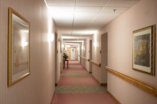 A well-lit corridor featuring a soothing color palette and carpet.