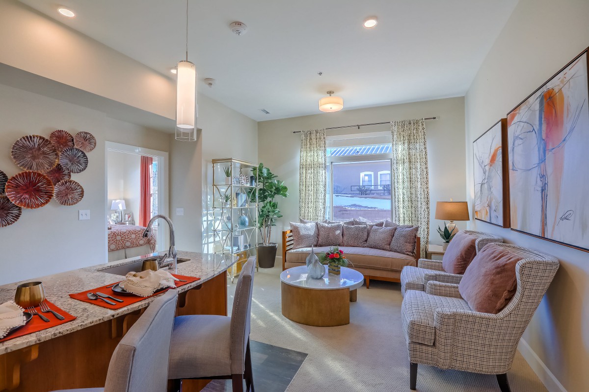 A modern and cozy living room with natural light, featuring stylish furniture and open space.
