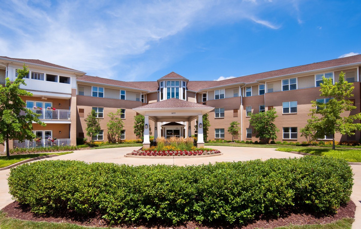 Exterior view of a large residential building with a landscaped entrance.