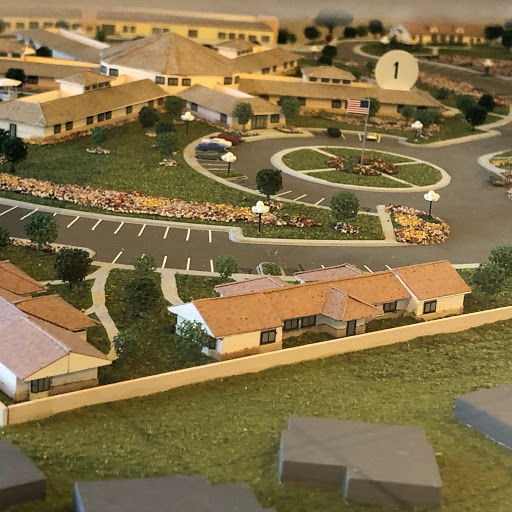 A scale model of a residential community showcasing buildings, landscaping, and parking areas.