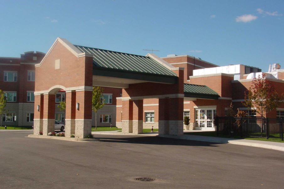 A modern healthcare facility with a prominent entrance, featuring brick and concrete construction.