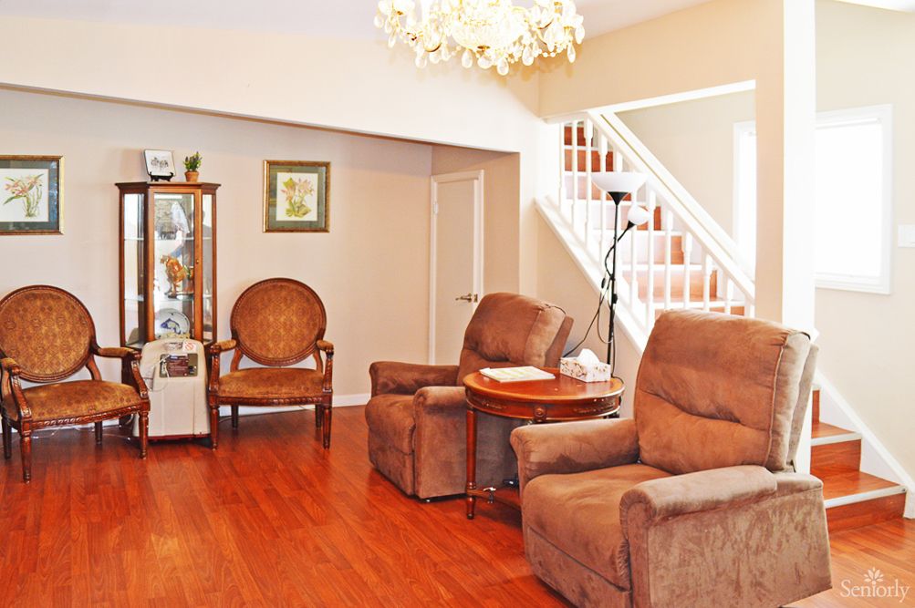 A cozy living room with brown recliner chairs, a wooden floor, and a staircase leading to the upper level.