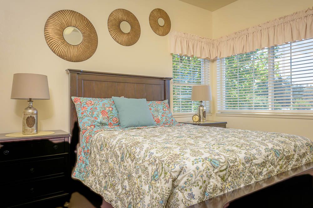 A cozy bedroom with decorative wall hangings and a comfortably made bed.