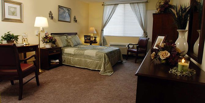 A cozy bedroom with a neatly made bed, soft lighting, and elegant curtains.