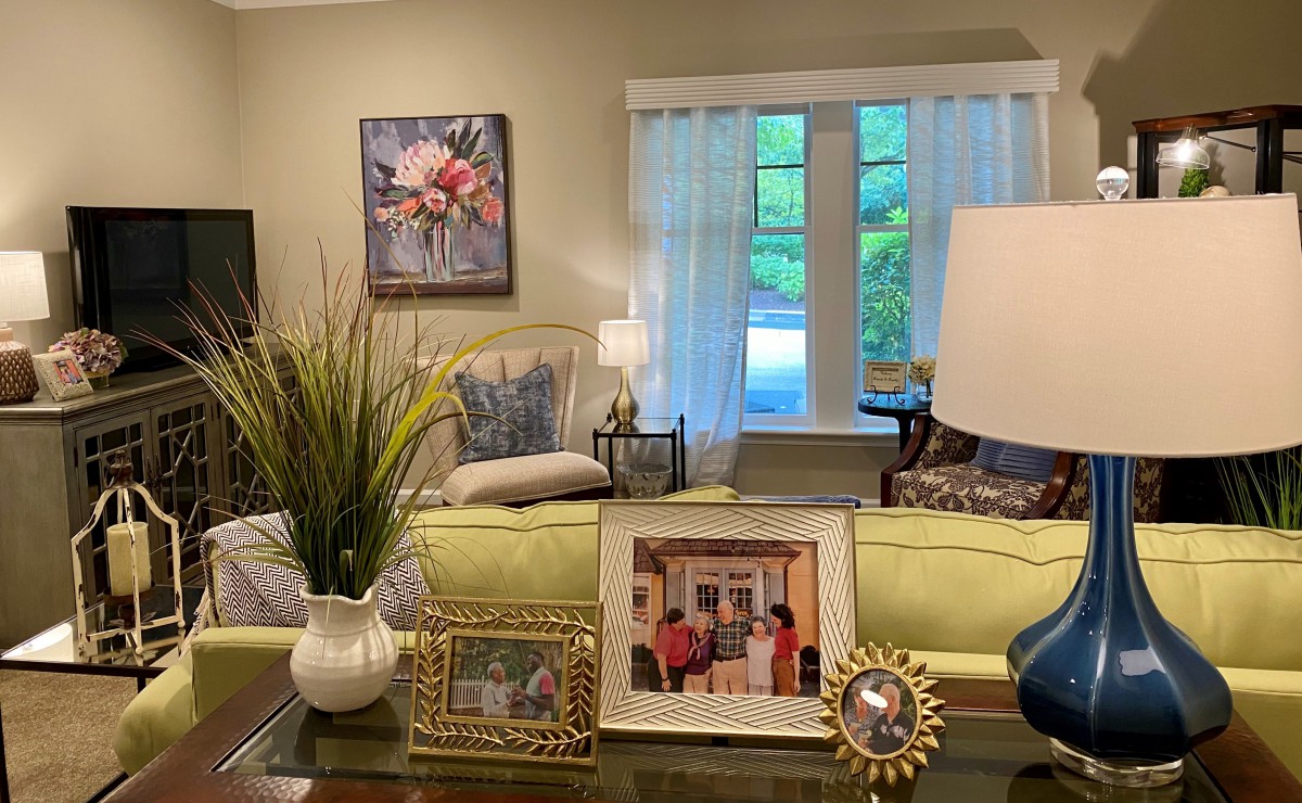 A cozy living room with a sofa, coffee table adorned with family photos, and elegant decor.