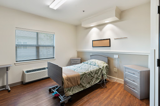 A clean and modern hospital patient room equipped with a bed and essential amenities.