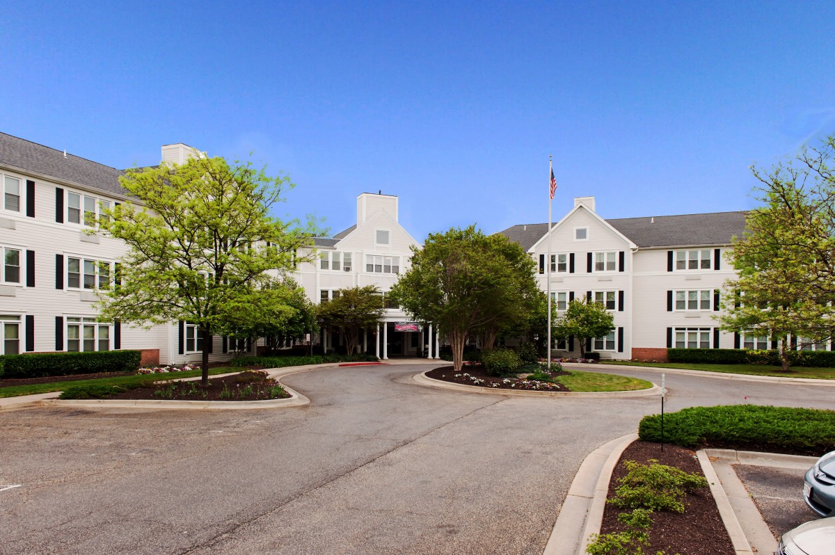 Exterior view of a hotel with landscaped surroundings and a driveway leading to the entrance.