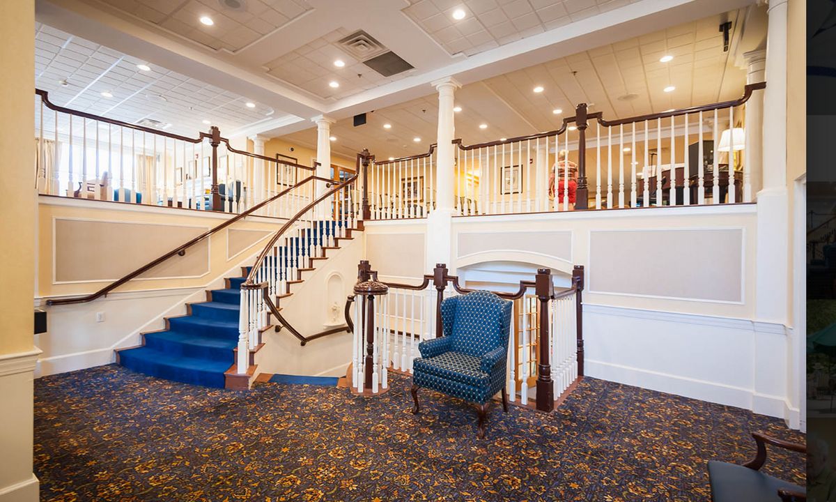 A well-lit lobby with a staircase and seating area.