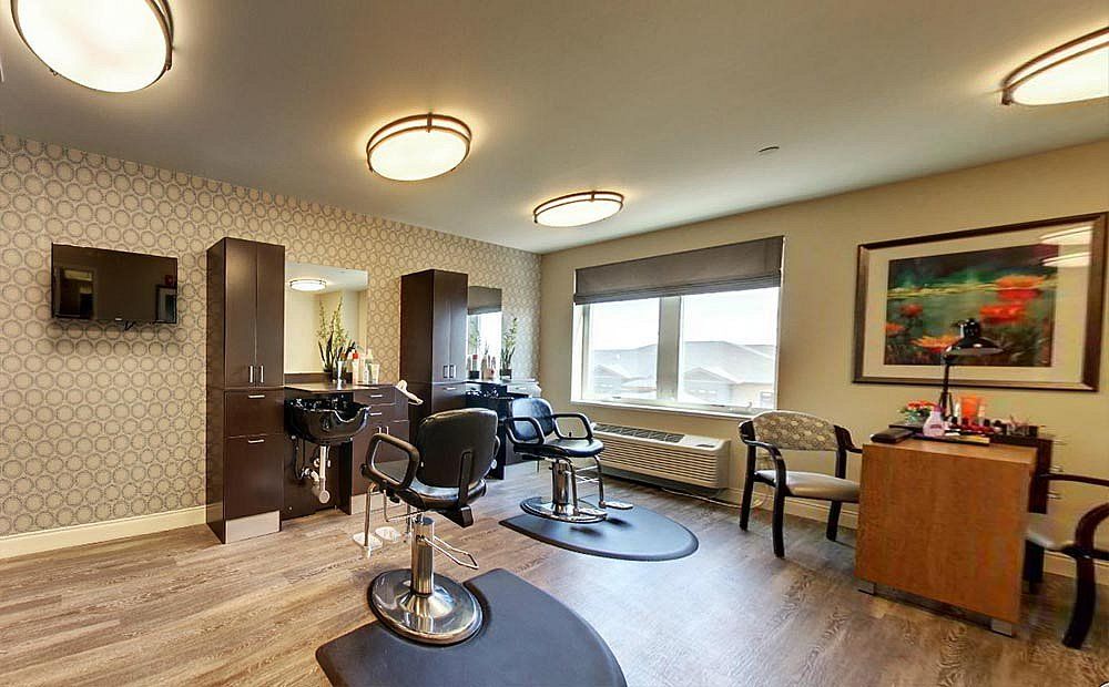 A modern hair salon interior with chairs and mirrors under bright lighting.