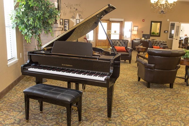 A grand piano in a cozy living room setting with elegant furniture and decor.