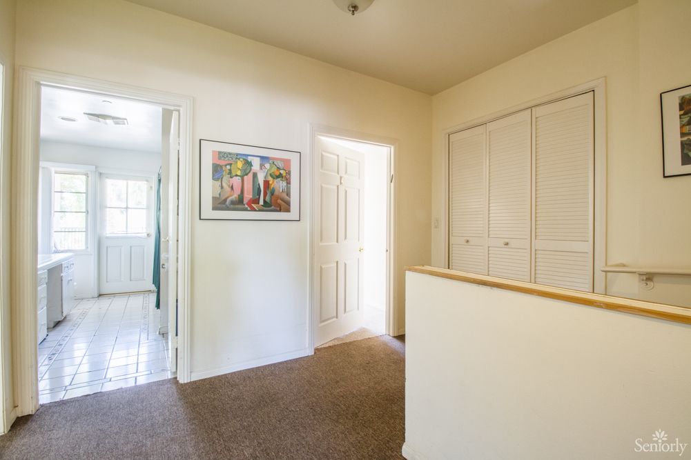 A well-lit hallway with doors leading to different rooms.