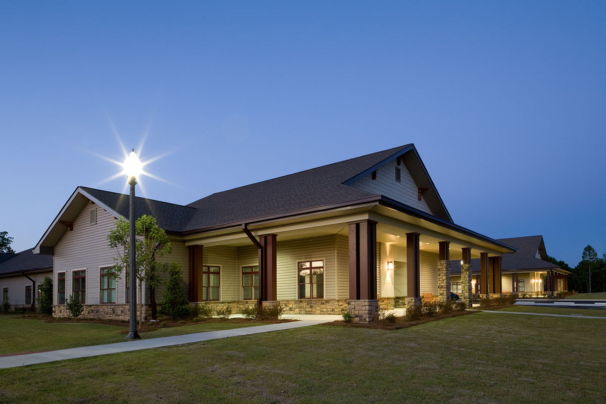 A modern building illuminated during the evening with a clear sky backdrop.