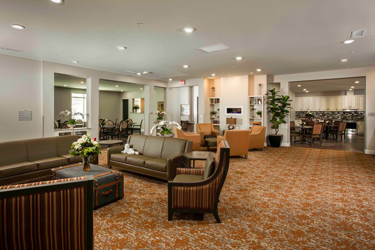 A spacious and elegantly furnished living room with ample seating and warm lighting.