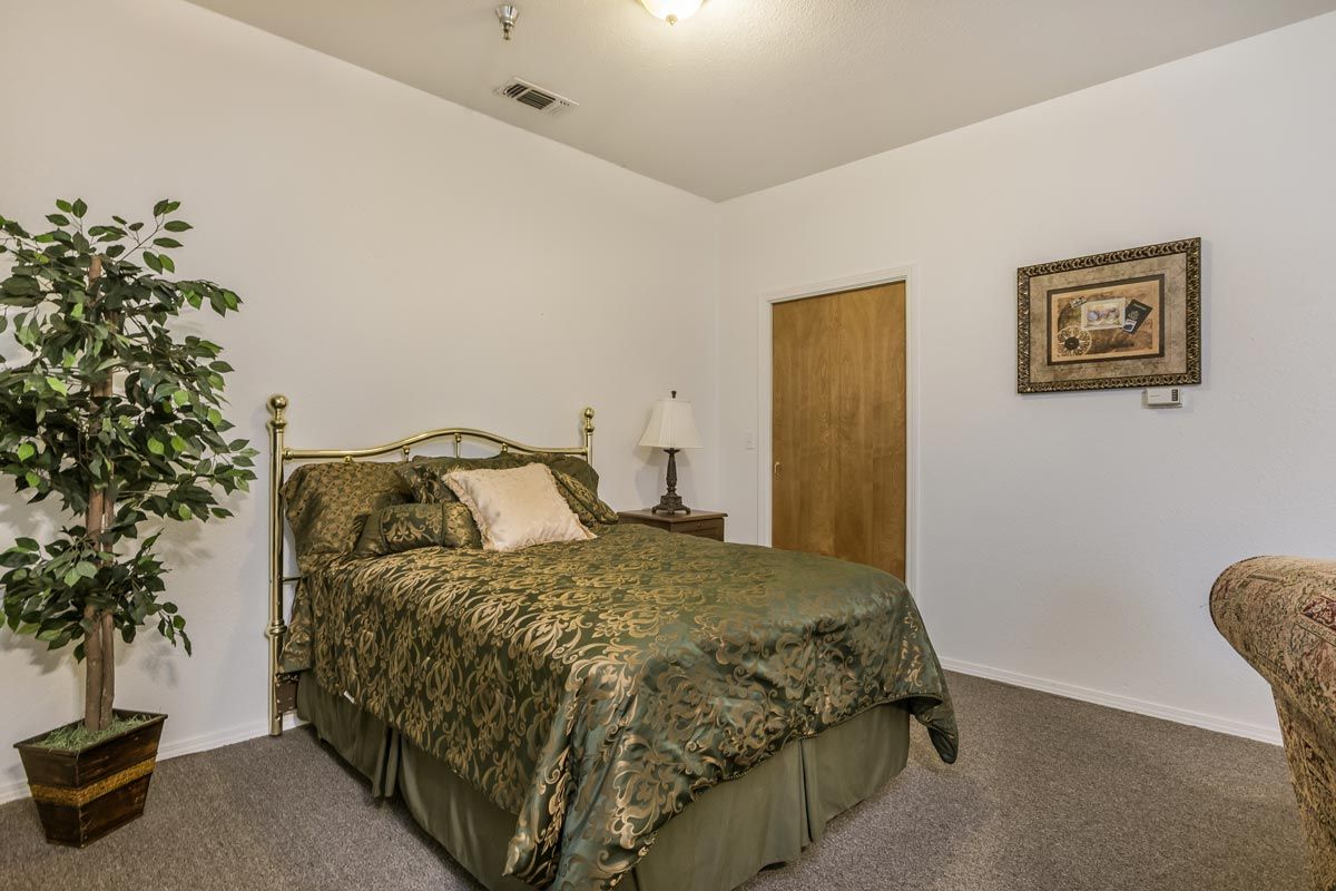 A cozy bedroom with green bedding and simple decor.