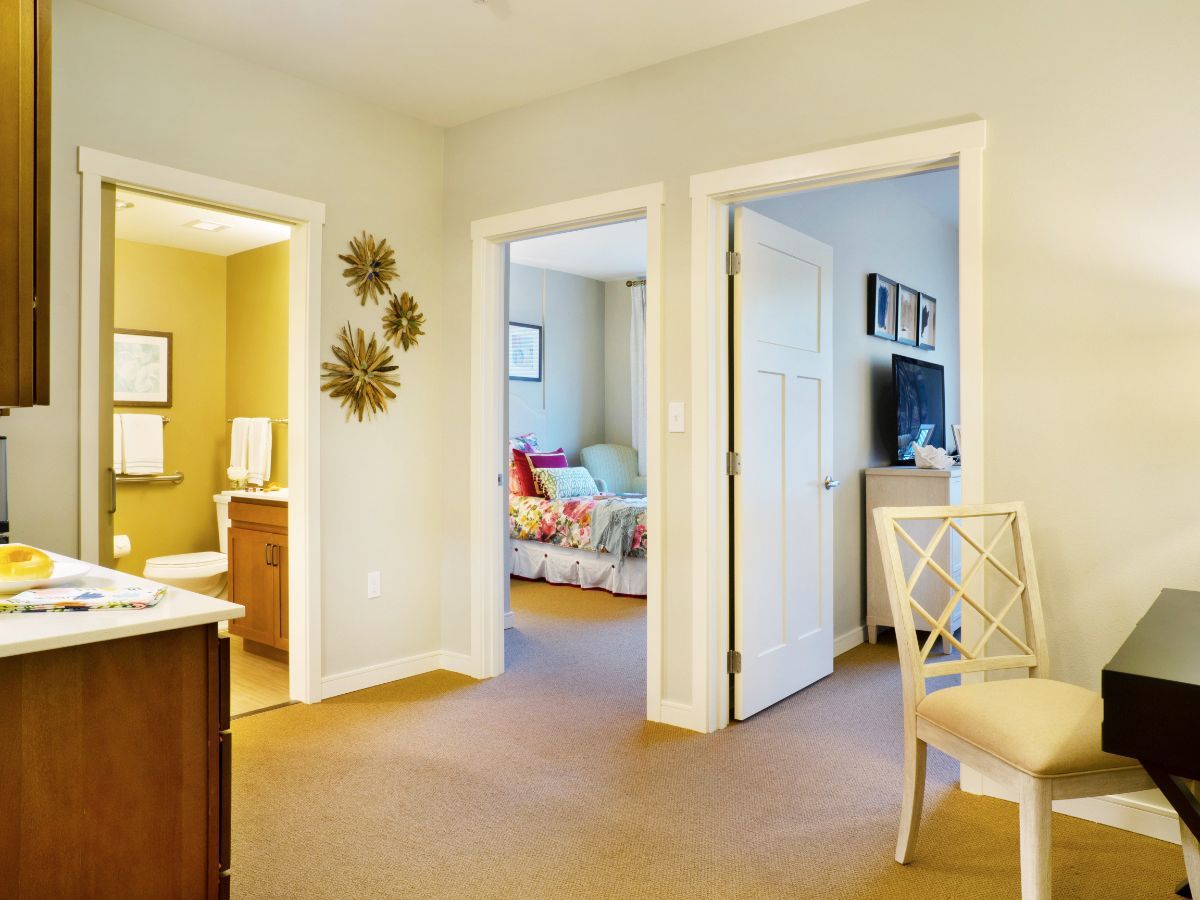 A cozy interior view showing a hallway leading to a bedroom and living area, with elegant decor and comfortable furnishings.