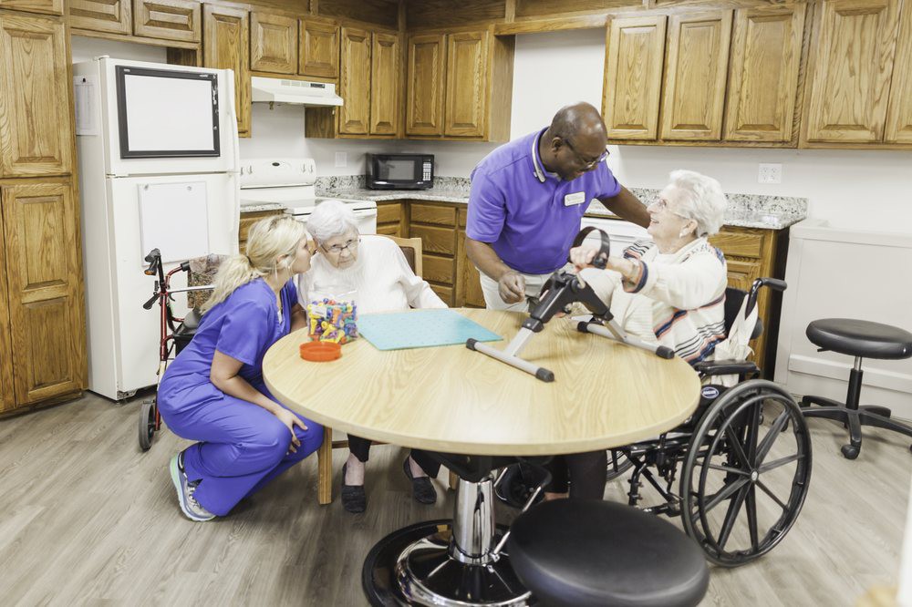 Caregivers assisting elderly residents in a nursing home setting.