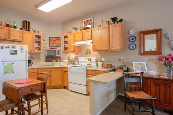 A cozy kitchen with wooden cabinets, modern appliances, and a small dining area.
