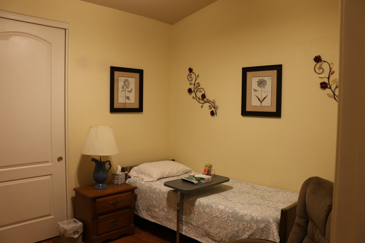 A cozy bedroom with a single bed, nightstand, and decorative wall art.