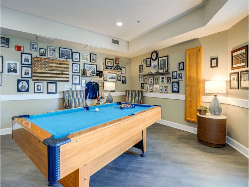 A stylish game room featuring a pool table and walls adorned with numerous framed pictures.