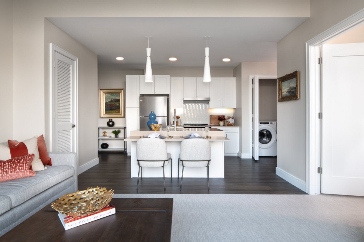 A modern kitchen with an island counter and stainless steel appliances.