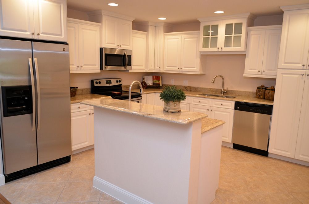 Modern kitchen with white cabinets and stainless steel appliances.