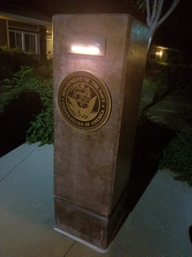 A illuminated monument featuring a seal, captured at night.