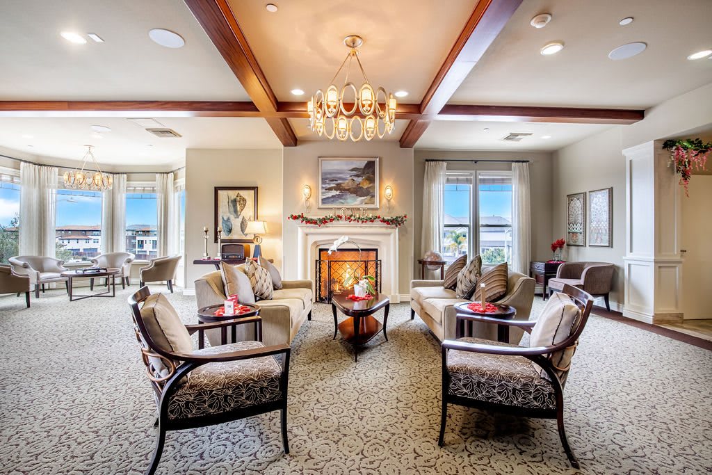 A luxurious living room with elegant seating, a chandelier, and a cozy fireplace.