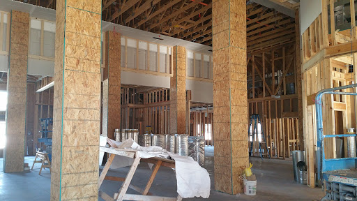 An interior view of an unfinished construction site featuring exposed wooden beams and framework.