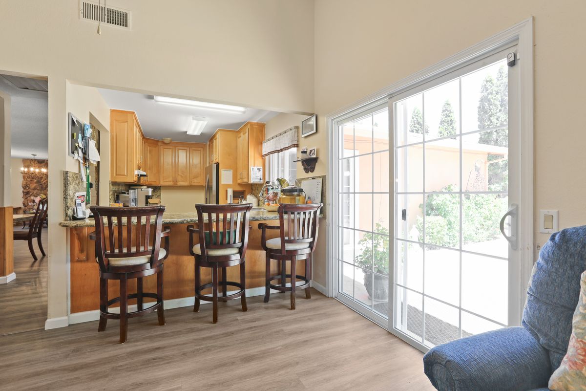 A cozy kitchen with a breakfast bar and sliding glass doors letting in natural light.