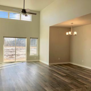 Spacious living and dining area with hardwood floors and large windows.