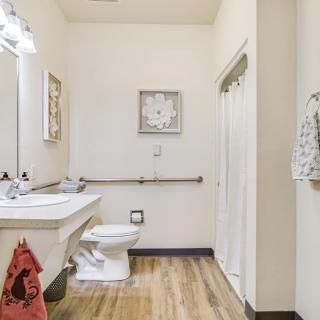 A clean and well-organized bathroom with a toilet, sink, and wall decor.