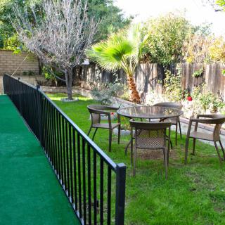 A tranquil backyard garden with a table, chairs, and lush greenery.