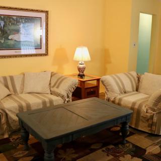 A cozy living room with sofas, a coffee table, and ambient lighting.