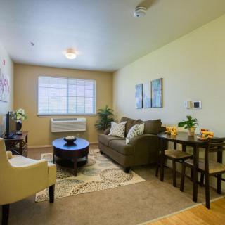 Cozy living room with a sofa, armchair, and dining area.