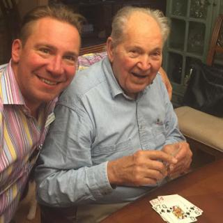 A joyful moment shared between two men while playing cards.
