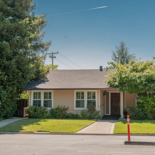 A single-story suburban house with a well-maintained front yard and trees.