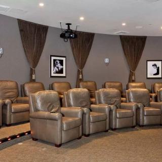 A cozy home theater with leather recliners and wall-mounted projector.